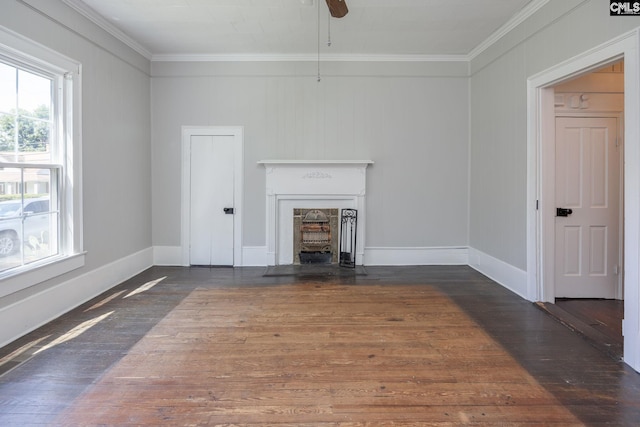 unfurnished living room with a fireplace with flush hearth, ornamental molding, baseboards, and wood finished floors