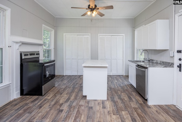 kitchen with stainless steel appliances, dark wood-type flooring, a sink, and white cabinetry