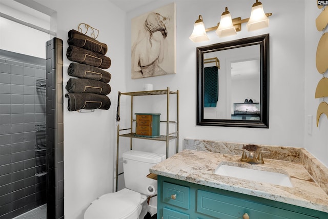 full bath featuring tiled shower, vanity, and toilet