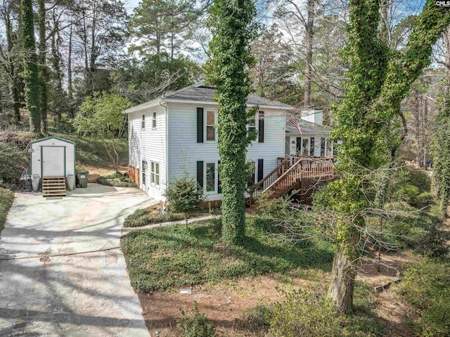 view of front of home featuring stairs, a storage shed, an outdoor structure, and a wooden deck