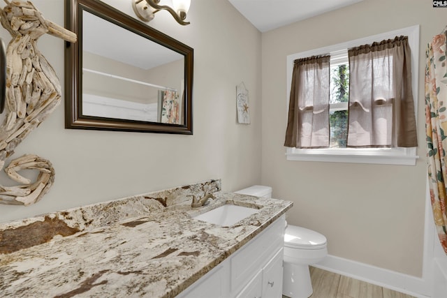 full bath featuring toilet, curtained shower, baseboards, and vanity