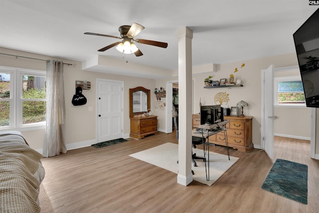 interior space with light wood-type flooring, ceiling fan, and baseboards