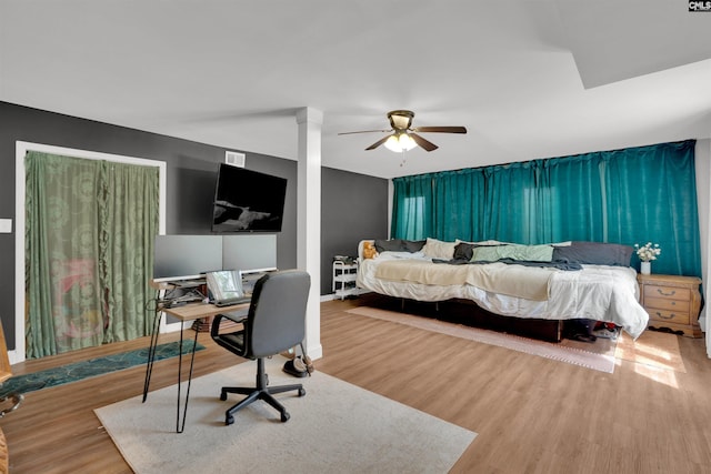 bedroom with baseboards, visible vents, a ceiling fan, and wood finished floors