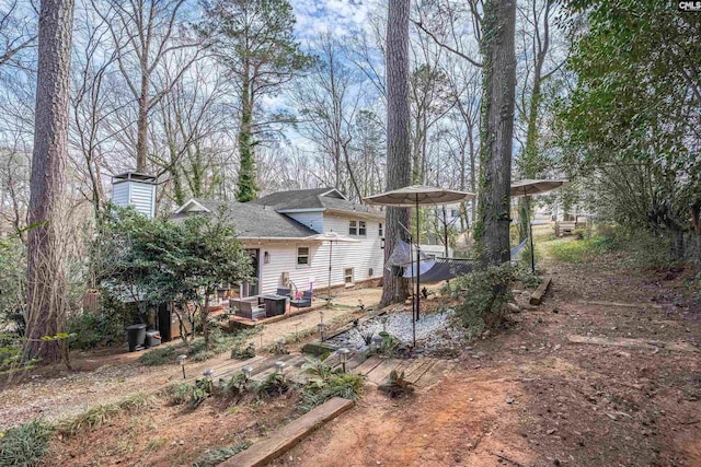 back of house with a carport and a chimney