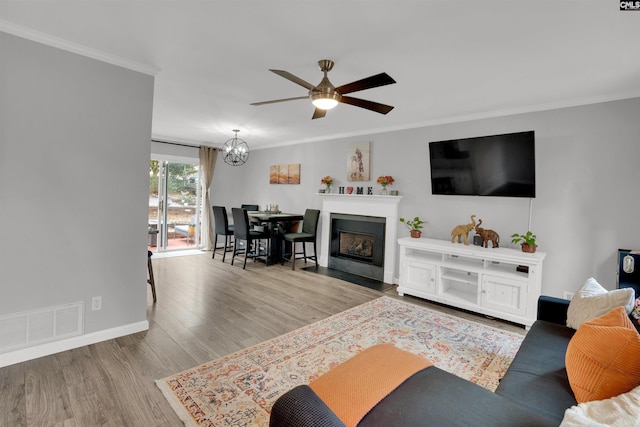 living room with visible vents, crown molding, and wood finished floors