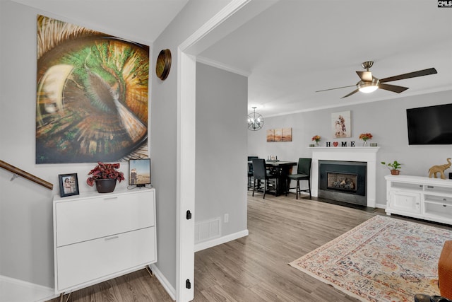 interior space with baseboards, visible vents, wood finished floors, and ornamental molding