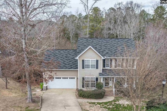 traditional home with a shingled roof, driveway, and an attached garage