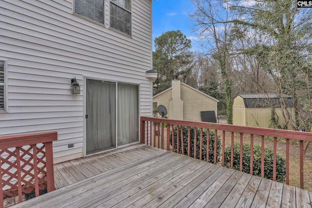 wooden deck featuring a storage unit and an outdoor structure