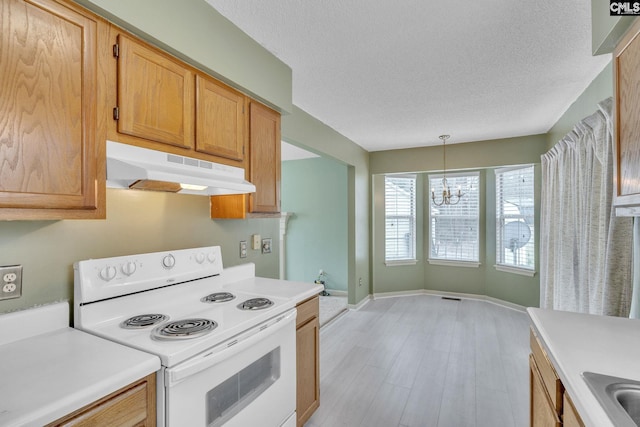 kitchen with visible vents, light countertops, a textured ceiling, under cabinet range hood, and white range with electric cooktop