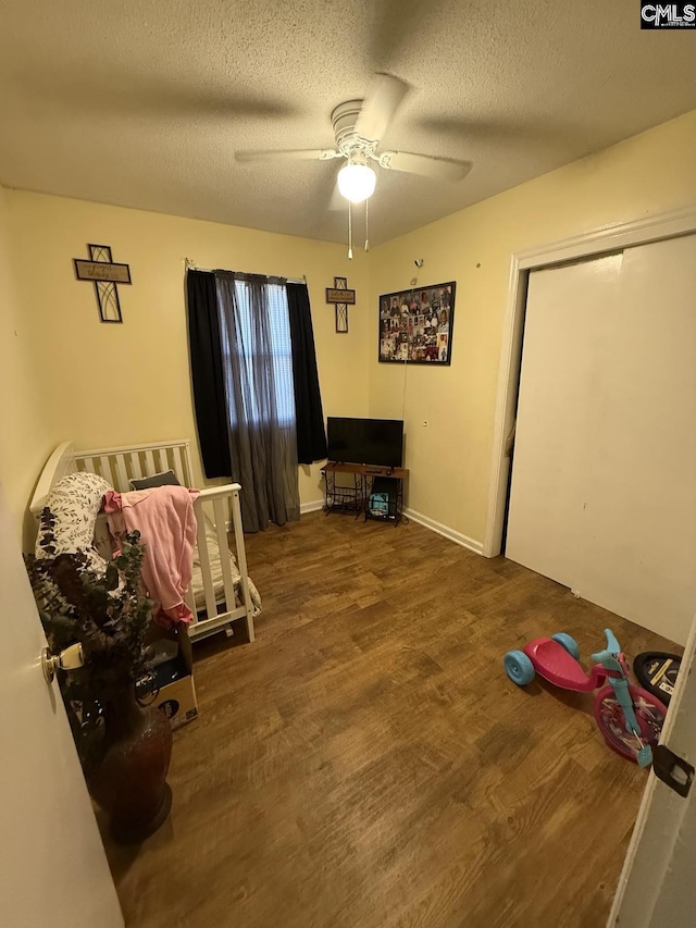 interior space with ceiling fan, wood finished floors, and a textured ceiling