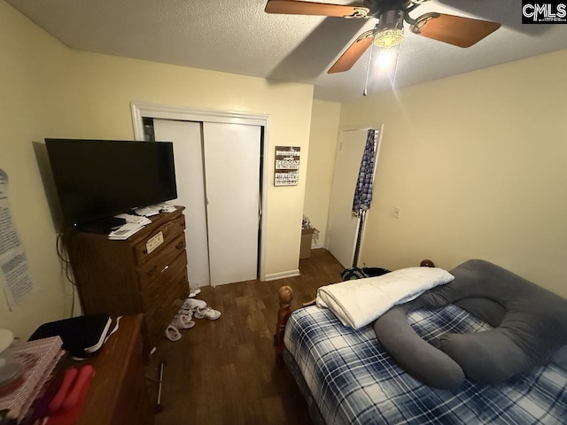 bedroom featuring a ceiling fan, a closet, a textured ceiling, and wood finished floors