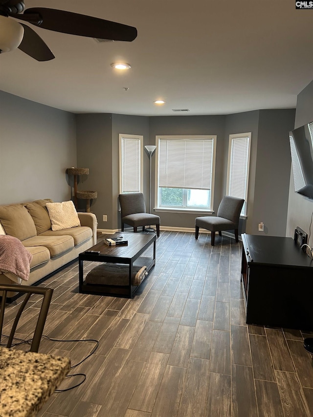 living room with ceiling fan, wood finish floors, and baseboards