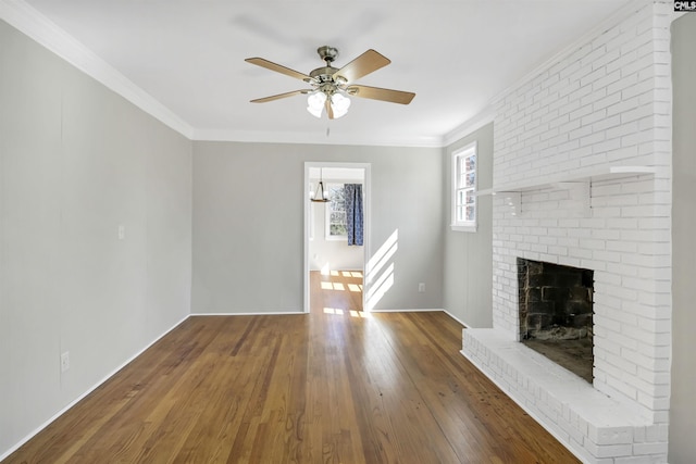 unfurnished living room with ceiling fan, a brick fireplace, hardwood / wood-style flooring, and crown molding