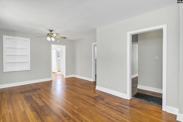 unfurnished room featuring hardwood / wood-style floors, built in shelves, and baseboards