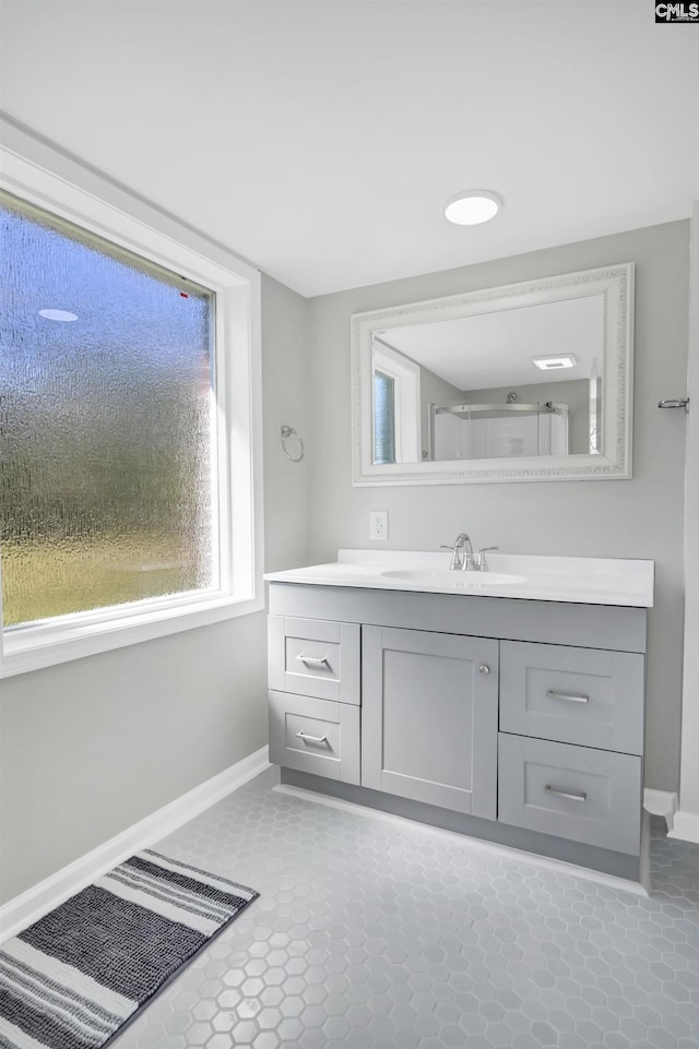 bathroom with tile patterned flooring, baseboards, and vanity