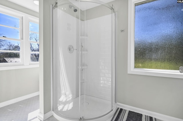 bathroom featuring a stall shower and baseboards