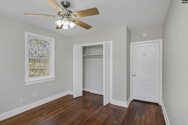 unfurnished bedroom featuring a closet, dark wood-style flooring, ceiling fan, and baseboards