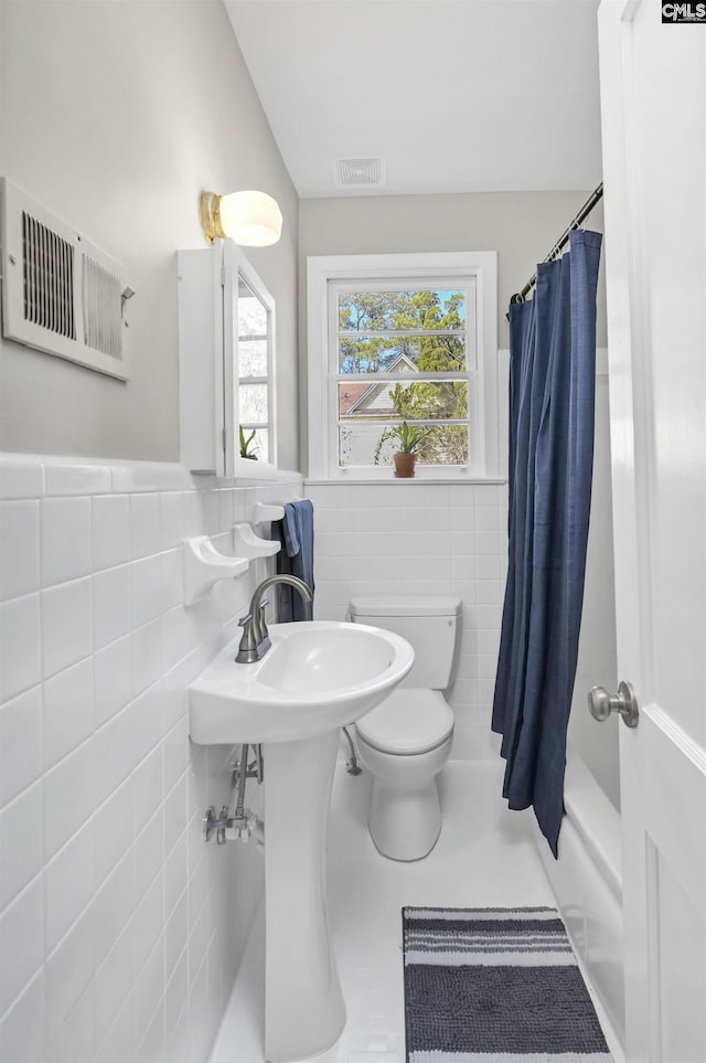 bathroom with visible vents, tile walls, tile patterned floors, a wainscoted wall, and toilet