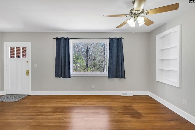 entryway with a ceiling fan, wood finished floors, visible vents, and baseboards