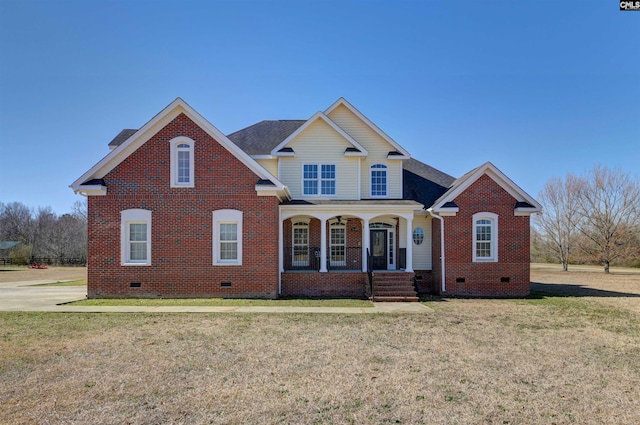 traditional-style house with a porch, brick siding, roof with shingles, crawl space, and a front lawn