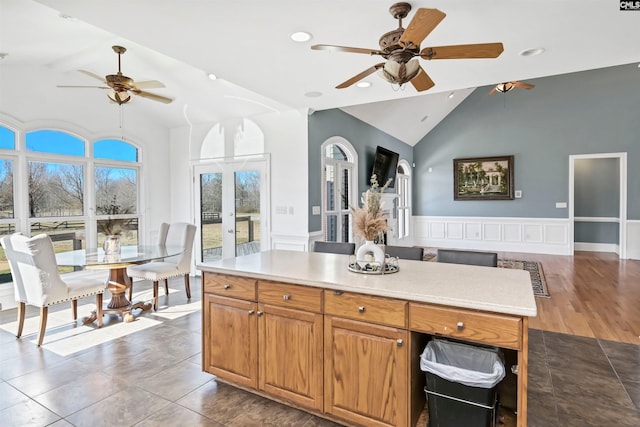 kitchen with light countertops, french doors, a wainscoted wall, and open floor plan