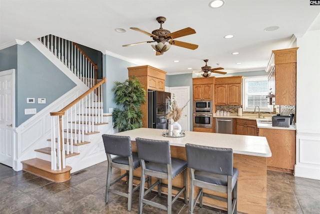 kitchen featuring crown molding, stainless steel appliances, light countertops, visible vents, and a kitchen island