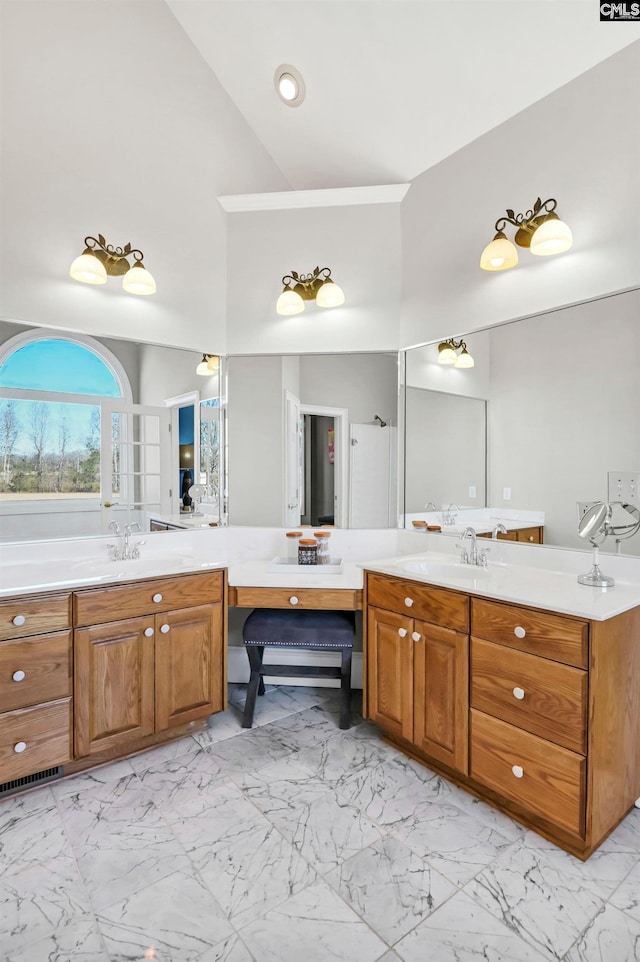 bathroom with marble finish floor, a towering ceiling, and vanity