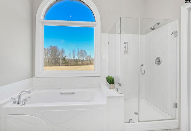 bathroom featuring a garden tub and a shower stall