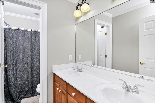 full bath featuring toilet, crown molding, double vanity, and a sink