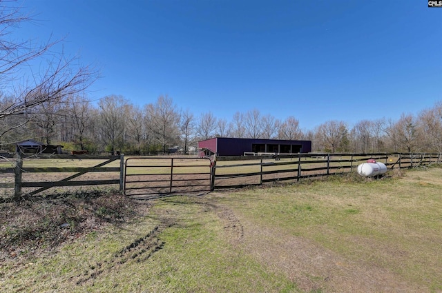 exterior space featuring an exterior structure, an enclosed area, a rural view, and an outdoor structure