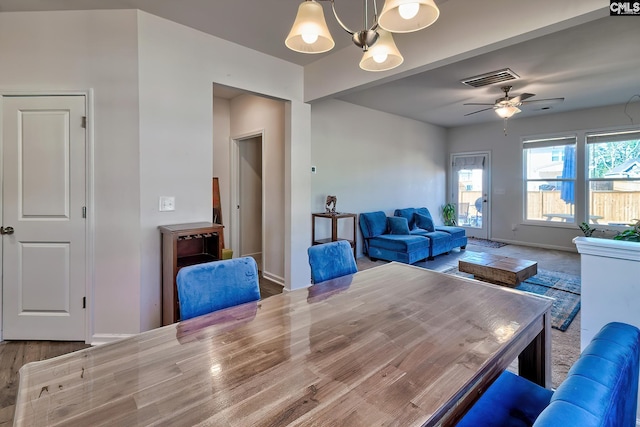 dining room with baseboards, visible vents, and ceiling fan with notable chandelier