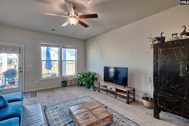 carpeted living room featuring a ceiling fan, visible vents, and baseboards