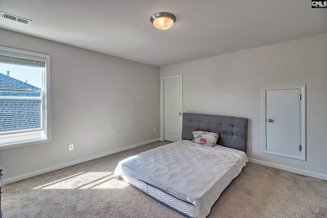 carpeted bedroom featuring visible vents and baseboards