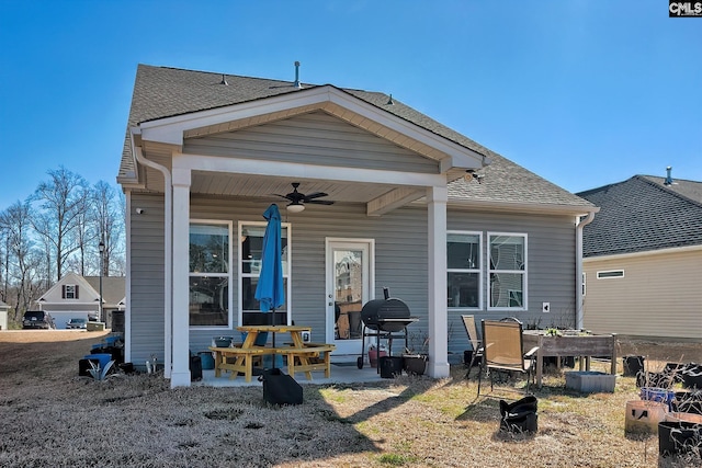 back of house featuring a ceiling fan and a shingled roof