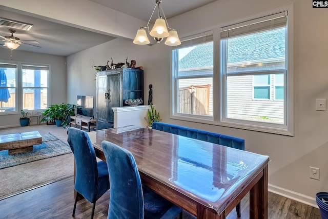 dining area featuring ceiling fan with notable chandelier, baseboards, and wood finished floors