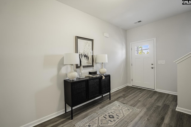 foyer featuring baseboards, visible vents, and dark wood-type flooring