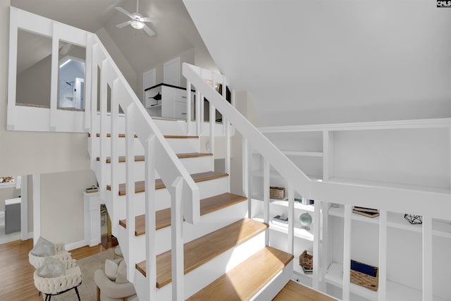 stairs with lofted ceiling, a ceiling fan, and wood finished floors