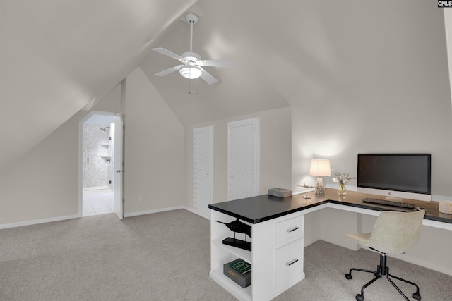 home office featuring light carpet, vaulted ceiling, a ceiling fan, and baseboards