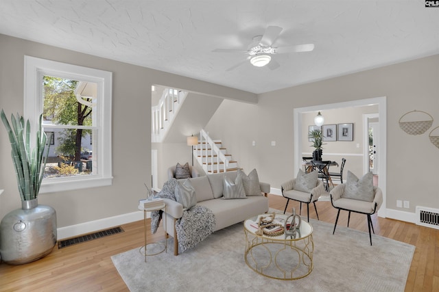 living area featuring stairway, wood finished floors, and visible vents