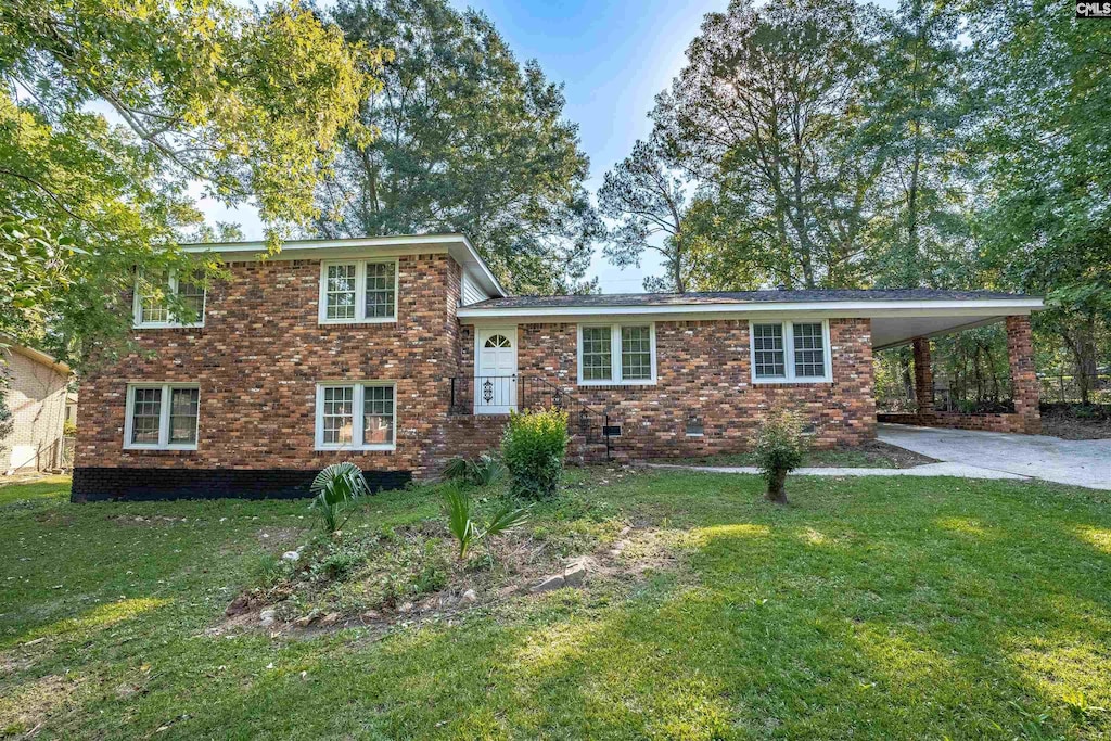 tri-level home with driveway, crawl space, a front lawn, a carport, and brick siding