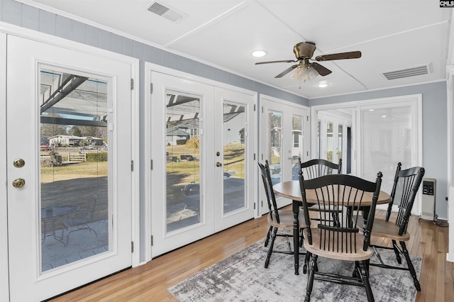 dining area featuring french doors, wood finished floors, visible vents, and crown molding