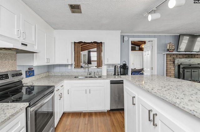 kitchen with visible vents, light wood-style flooring, white cabinetry, a sink, and stainless steel range with electric stovetop