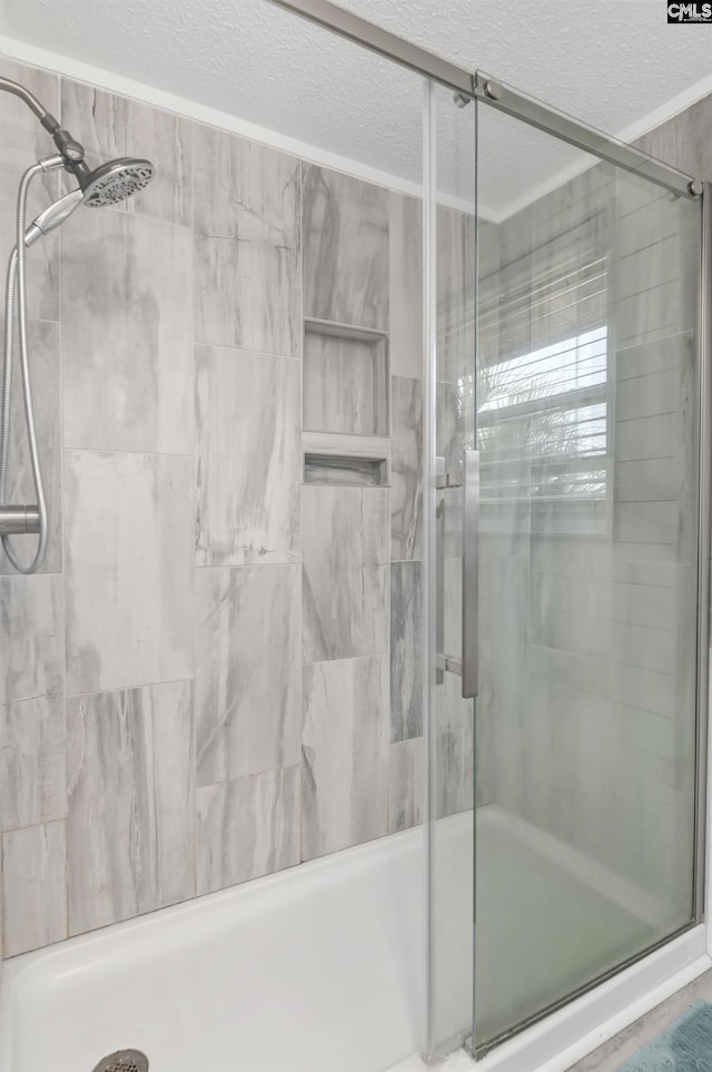 bathroom featuring a shower stall and a textured ceiling