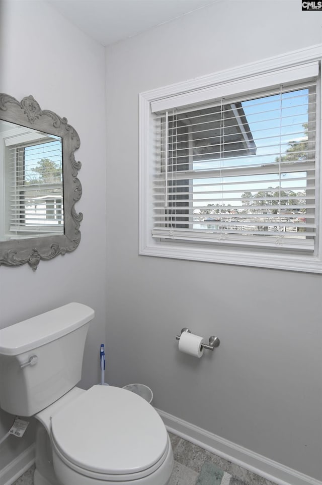 bathroom with baseboards and toilet