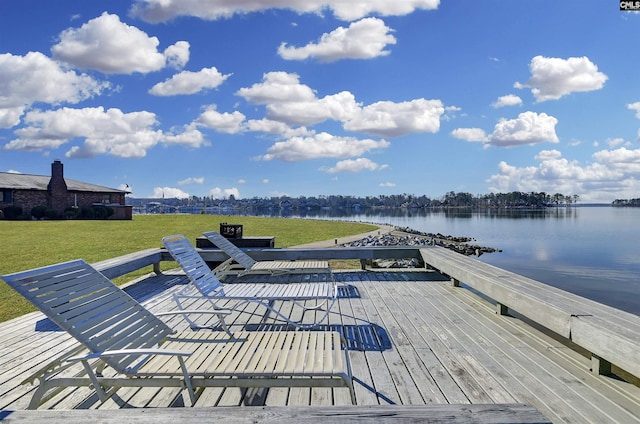 deck featuring a water view and a lawn