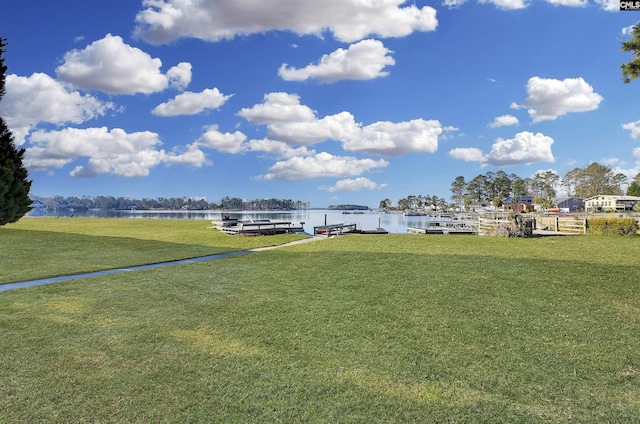 view of yard featuring a water view and a boat dock