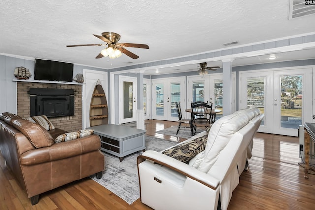 living room featuring french doors, wood finished floors, and visible vents