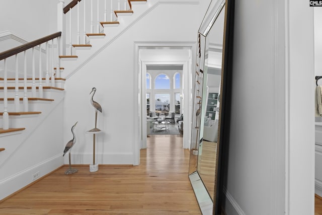 interior space featuring light wood finished floors, stairway, and baseboards