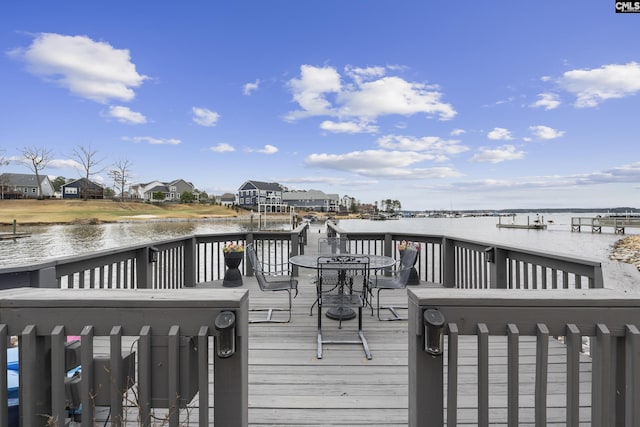 wooden terrace featuring a water view and outdoor dining space