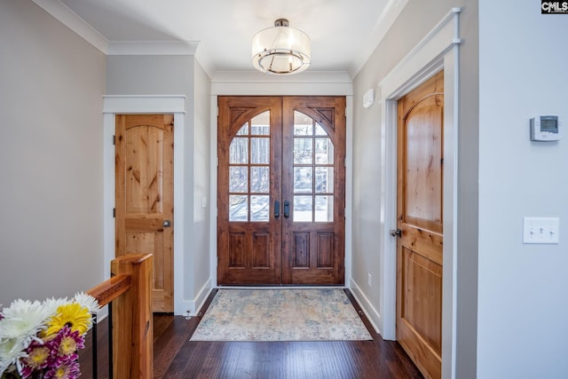 entrance foyer with dark wood-type flooring, ornamental molding, and baseboards